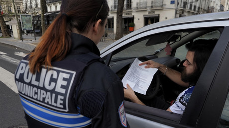L'attestation de déplacement dérogatoire d'un automobiliste est contrôlée par une policière à Tours (Indre-et-Loire) lors du premier confinement, le 17 mars 2020 (image d'illustration).
