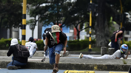 Des manifestants cherchent à s'abriter lors d'affrontements avec la police dans le cadre d'une nouvelle manifestation contre le gouvernement du président colombien Ivan Duque, à Cali, le 28 mai.