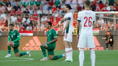 Des joueurs de l'équipe d'Irlande, le genou à terre, et des joueurs hongrois, à Budapest, le 8 juin 2021.