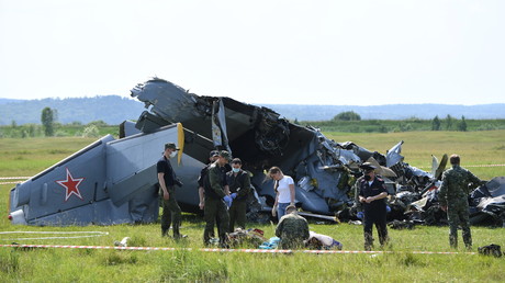 Des policiers et des inspecteurs russes devant les débris de l'appareil, près de l'aérodrome de Tanay, en Russie, le 19 juin 2021.