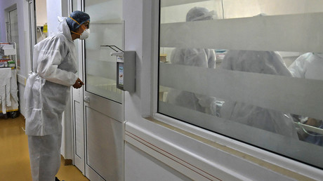 Un médecin regarde ses collègues réanimer un patient contaminé au Covid-19 à l'unité de soins intensifs de l'hôpital Ariana Abderrahmen Mami de la ville d'Ariana, le 27 janvier 2020 (image d'illustration).