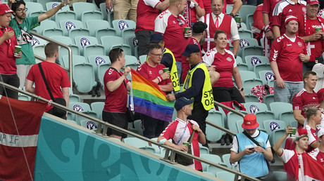 Des stadiers interviennent auprès d'un supporter danois qui brandit un drapeau arc-en-ciel avant le match de football entre la République tchèque et le Danemark au stade olympique de Bakou, le 3 juillet 2021.