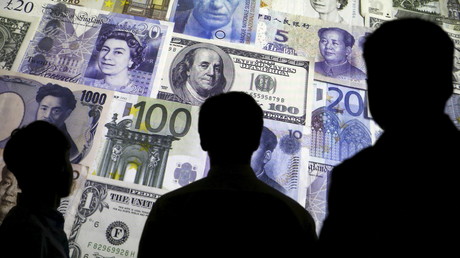 Image d'illustration montrant des silhouettes devant des billets de banque de différentes devises nationales, le 4 avril 2016.