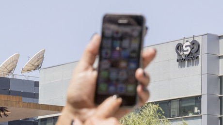 Un smartphone brandi devant l'entreprise NSO qui vend le logiciel d'espionnage Pegasus, août 2016 à Herzliya, Israël (image d'illustration).