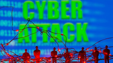 Montage photographique réalisé avec des lampes LED et des figurines sur fonds de code binaire devant lequel est affiché la locution «Cyber attack» (cyber-attaque). Illustration réalisée le 5 juillet 2021.