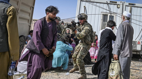 Un soldat américain pointe son arme vers un Afghan à l'aéroport de Kaboul, le 16 août 2021.