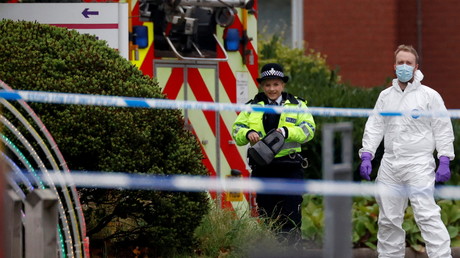 Des policiers, dont un médecin légiste, se tiennent près des lieux de l'explosion d'une voiture devant un hôpital à Liverpool (Angleterre), le 15 novembre 2021.