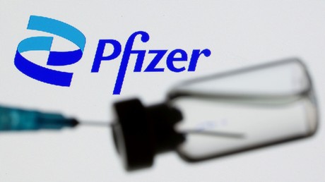 Un montage montrant une seringue prélevant du liquide dans un flacon devant le logo de Pfizer, à Zenica, le 24 juin 2021.