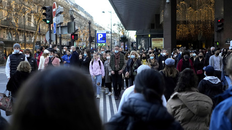 Des personnes portant un masque de protection contre le Covid-19 passent devant un grand magasin, à Paris, le 30 décembre 2021 (image d'illustration).