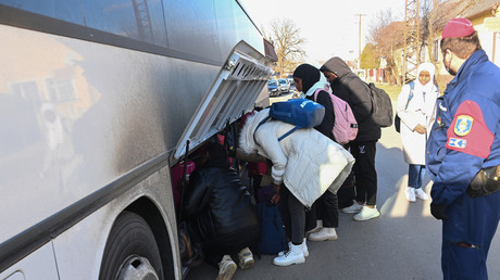 Des étudiants universitaires, dont de nombreux nigérians, fuyant la capitale ukrainienne Kiev, rangent leurs bagages alors qu'ils montent dans leur bus de transport, le 28 février 2022.