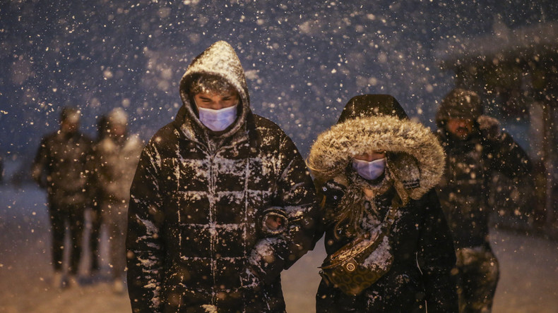 Des piétons partiellement recouverts de neige marchent près du pont de Galata pendant une chute de neige à Istanbul, en Turquie, le 12 mars 2022 (image d'illustration).