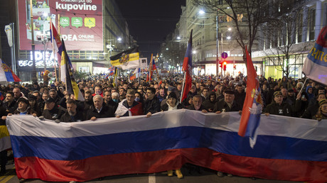 Des personnes tiennent un grand drapeau russe lors d'un rassemblement de soutien à la Russie à Belgrade, le 4 mars 2022.