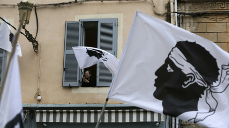 Une femme agite depuis sa fenêtre un drapeau corse le 13 mars 2022, lors d'un rassemblement de soutien à Yvan Colonna,  une semaine après son agression à la prison de Arles (image d'illustration).