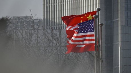 Des drapeaux nationaux chinois et américain flottent à l'entrée d'un immeuble de bureaux à Pékin le 19 janvier 2020.