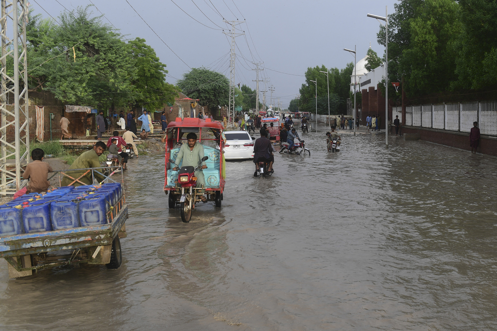 Des habitants se frayent un chemin dans une rue inondée après de fortes pluies de mousson à Jacobabad, dans la province de Sindh, le 26 août 2022.