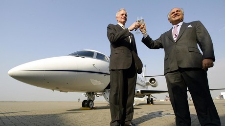 Deux dirigeants d'entreprises du secteur aérien d'affaires portent un toast devant un jet d'affaires Gulfstream G200 sur le tarmac de l'aéroport de Chek Lap Kok à Hong Kong en février 2004 (illustration).