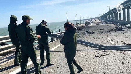 Image tirée d'une vidéo publiée par la Commission d'enquête russe : des enquêteurs travaillent sur le pont de Crimée, le 8 octobre 2022, après que l'explosion d'un camion et l'incendie qui s'en est suivi ont endommagé la structure.
