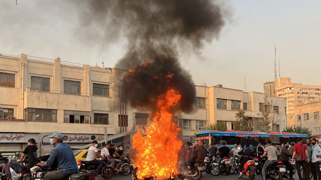 Une photo obtenue par l'AFP hors d'Iran, montre des personnes se rassemblant près d'une moto en feu dans la capitale Téhéran, le 8 octobre 2022.