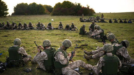 Des recrues ukrainiennes lubrifient leurs fusils d'assaut AK-47 au cours d'un entraînement au combat de cinq semaines avec les forces armées britanniques près de Durrington, dans le sud de l'Angleterre, le 11 octobre 2022.