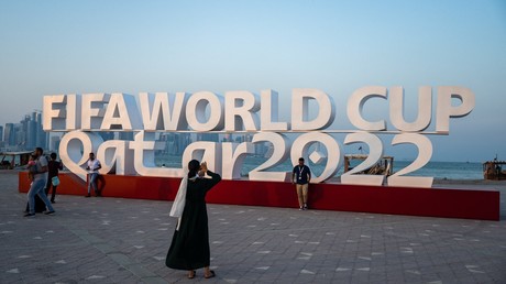 Des visiteurs prennent des photos avec un panneau de la Coupe du monde de la FIFA à Doha, le 23 octobre 2022.