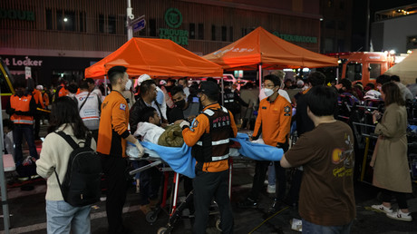 Des secouristes transportent des personnes blessées à Séoul, dans la nuit du 29 au 30 octobre.