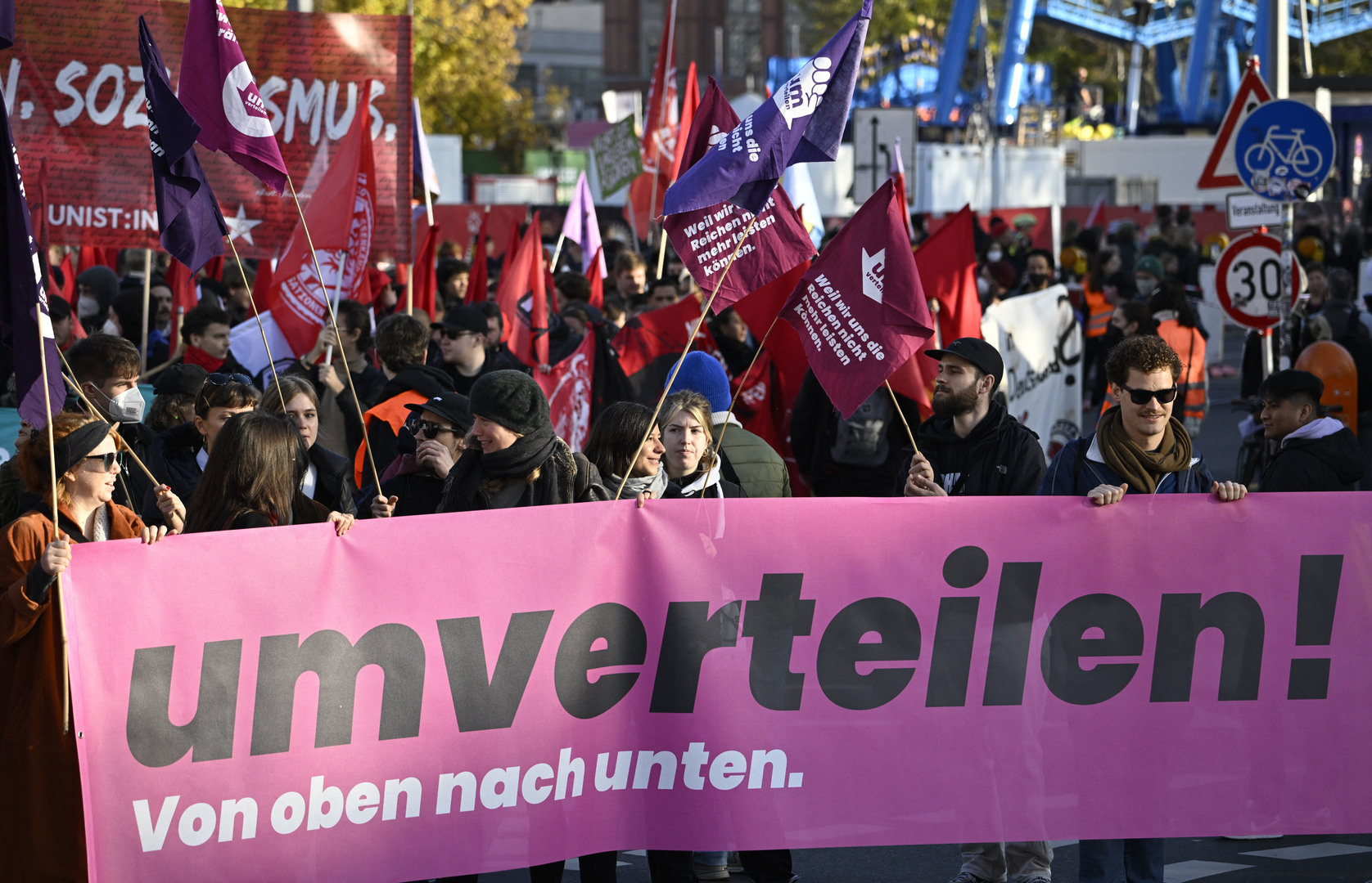 Les manifestants portent des banderoles et des drapeaux lors d’une manifestation intitulée « Umverteilen ! » (Redistribuer !) le 12 novembre 2022 à Berlin.