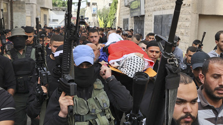 Des personnes en deuil portent le corps d'un jeune palestinien tué lors d'un raid israélien le 21 novembre 2022 dans la ville de Jénine en Cisjordanie.