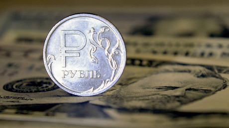 Une pièce de monnaie russe sur un billet de banque américain. (Photo d'illustration)