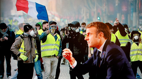 Emmanuel Macron parle devant un écran montrant une manifestation de Gilets jaunes (image d'illustration).