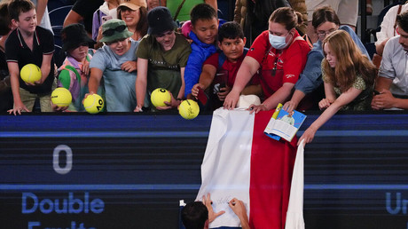 Daniil Medvedev signe le drapeau russe d'un fan après sa victoire, le 16 janvier à l'Open d'Australie.