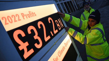 Des militants de Greenpeace ont installé un faux tableau des prix de station-service affichant le bénéfice net de Shell pour 2022, alors qu'ils manifestent devant le siège de la société à Londres le 2 février 2023.