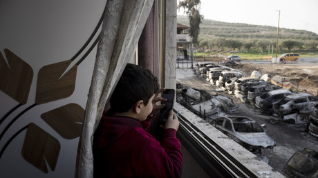Un garçon palestinien dans les ruines de l'appartement de sa famille alors qu'il filme les véhicules incendiés lors d'un saccage par des colons à Hawara, près de la ville de Naplouse en Cisjordanie, le 28 février 2023 (image d'illustration).