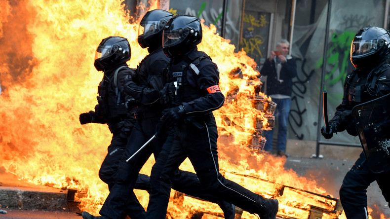 Des policiers français de la Brigade de répression de l'action violente motorisée (Brav-M) passent devant un feu lors d'une manifestation à Paris le 23 mars 2023 (image d'illustration).