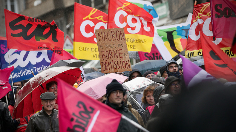 Des manifestants tiennent des drapeaux syndicaux lors d'un rassemblement contre une réforme des retraites à Vire, dans le nord-ouest de la France, le 1er avril 2023.