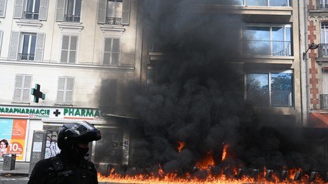 Policier de la BRAV-M devant l'incendie qui a menacé un immeuble, place de la Nation à Paris, le 1er mai 2023.