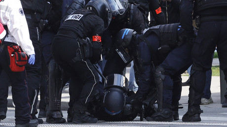 Des policiers aident un de leur collègue blessé lors de la manifestation parisienne, le 1er mai.