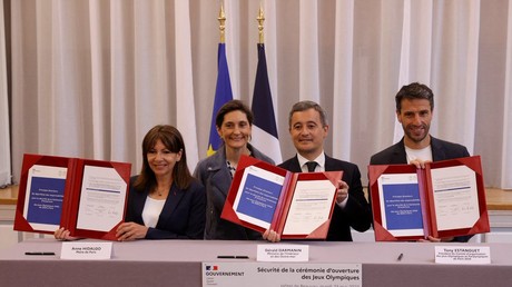 Gérald Darmanin (au centre) entouré de la maire de Paris Anne Hidalgo (à gauche) et du président du Comité d'organisation de Paris 2024 Tony Estanguet (à droite).
