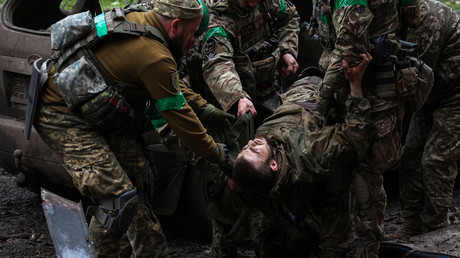 Des soldats ukrainiens transportent un camarade blessé sur le front du Donbass, en avril 2023 (image d'illustration).