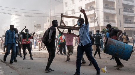 A Dakar le 9 février, des manifestants scandent des slogans et brûlent des planches et des pneus pour protester contre le report de l'élection présidentielle prévue initialement le 25 février.