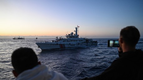 Des marins philippins photographient un navire chinois.
