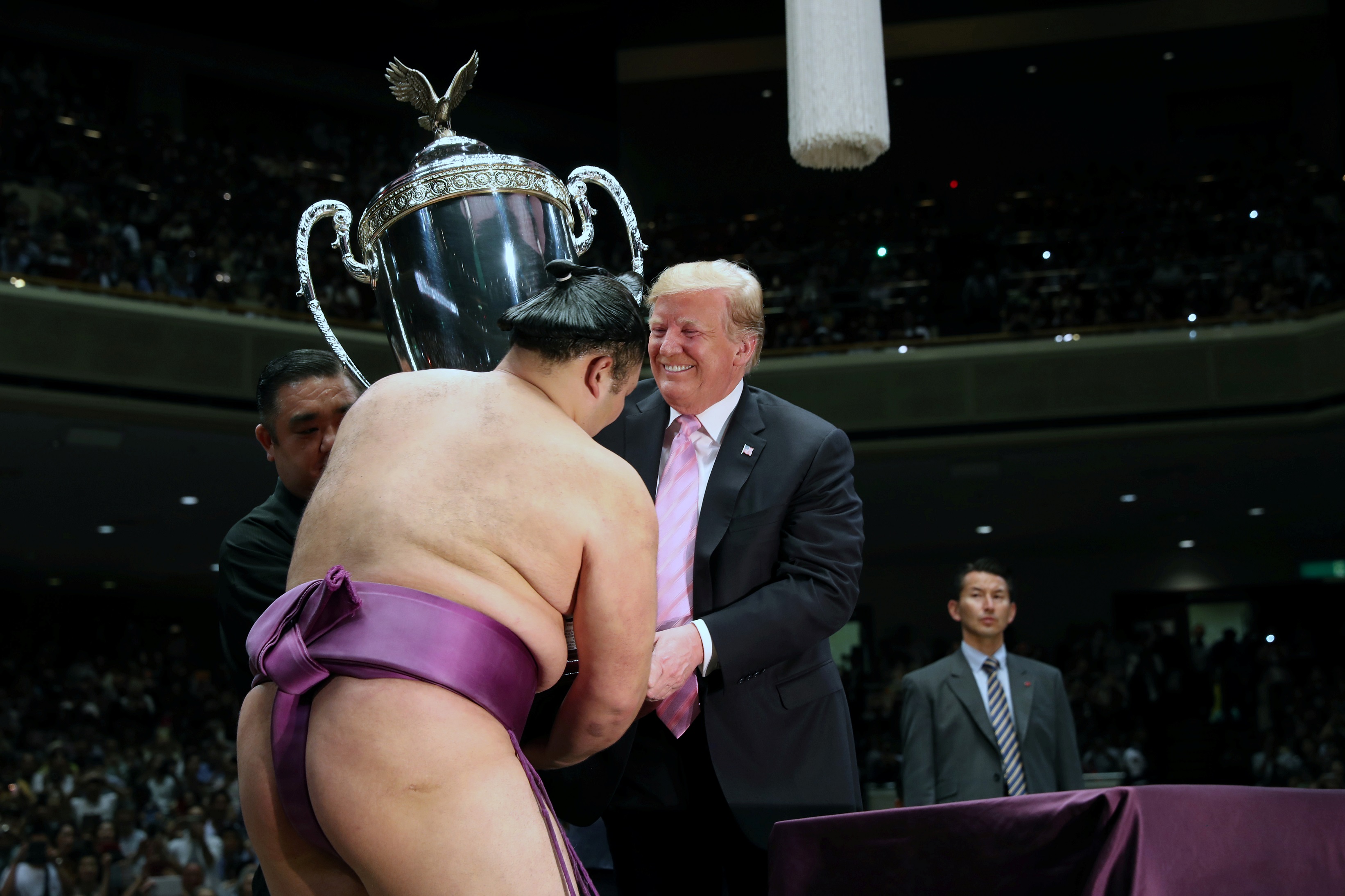 Лучезарный Трамп одаривает японского спортсмена кубком