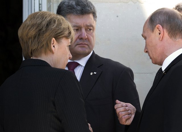 بوتين يتحدث مع بوروشينكو أثناء توجهه الى الغداء على هامش لقاءاته في فرنسا