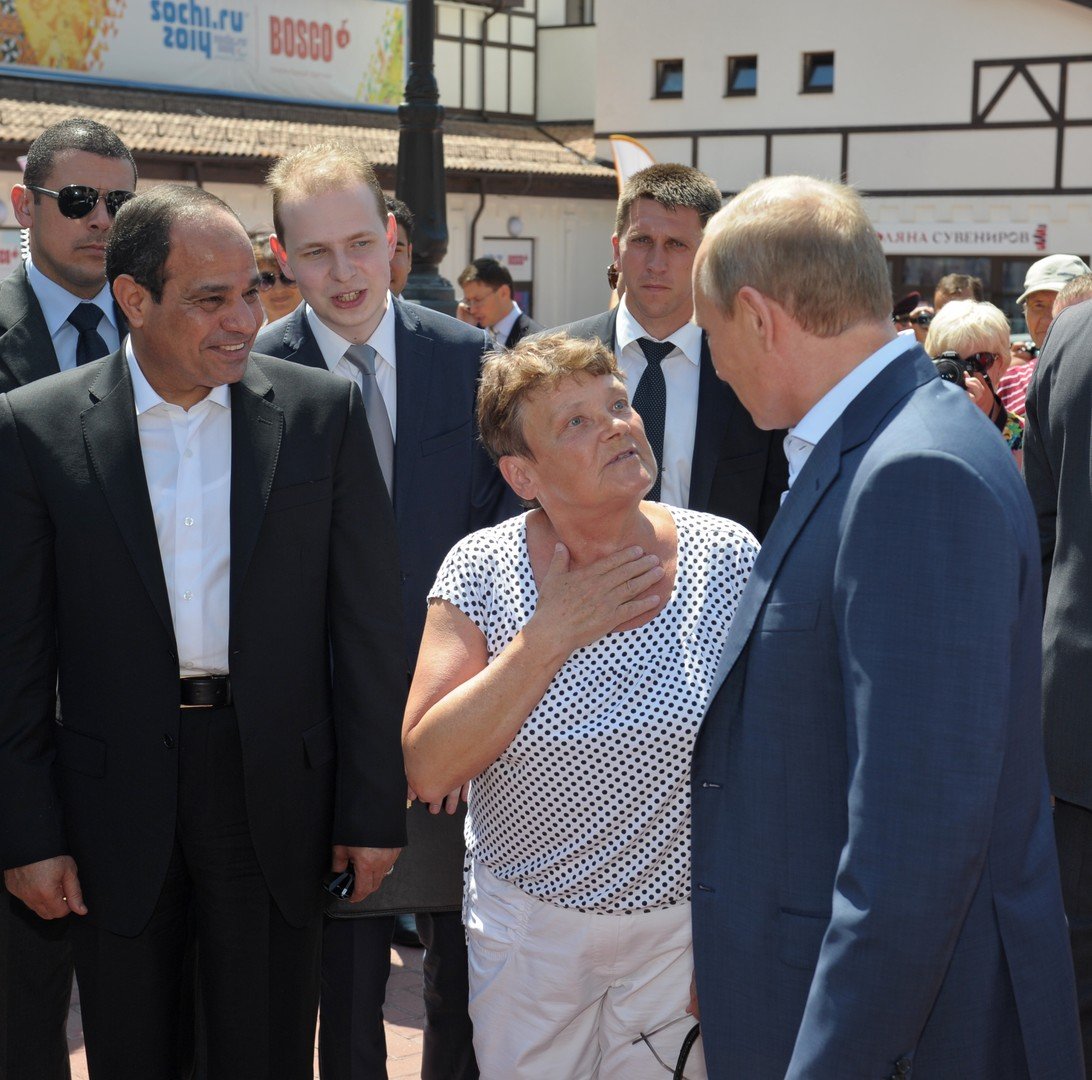 الرئيس بوتين يخاطب إمرأة محلية أثناء التنزه مع الرئيس السيسي في شارع بلدة روزا خوتور 12 أغسطس/آب.