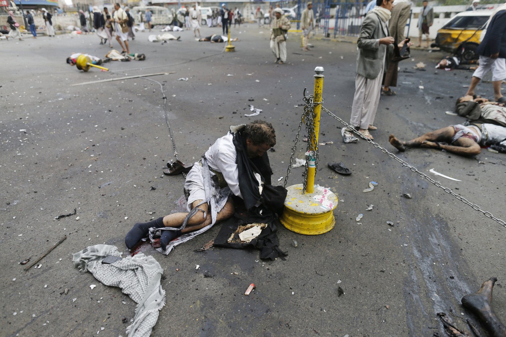 أحد الجرحى يحاول النهوض في مسرح الهجوم الانتحاري بصنعاء 9 أكتوبر/تشرين الأول 2014