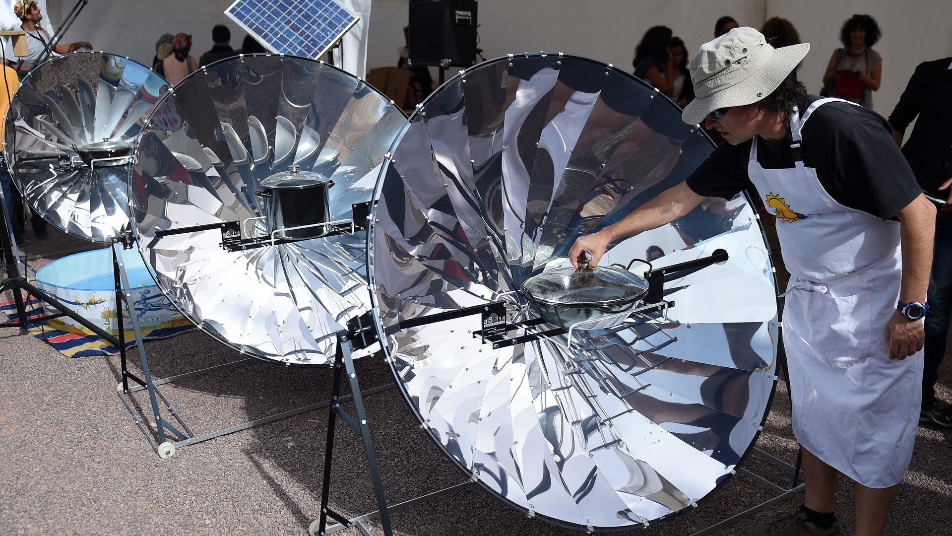 رجل يستخدم الطاقة الشمسية لطهي الطعام، خلال الدورة الأولى من مهرجان المغرب للطاقة الشمسية 