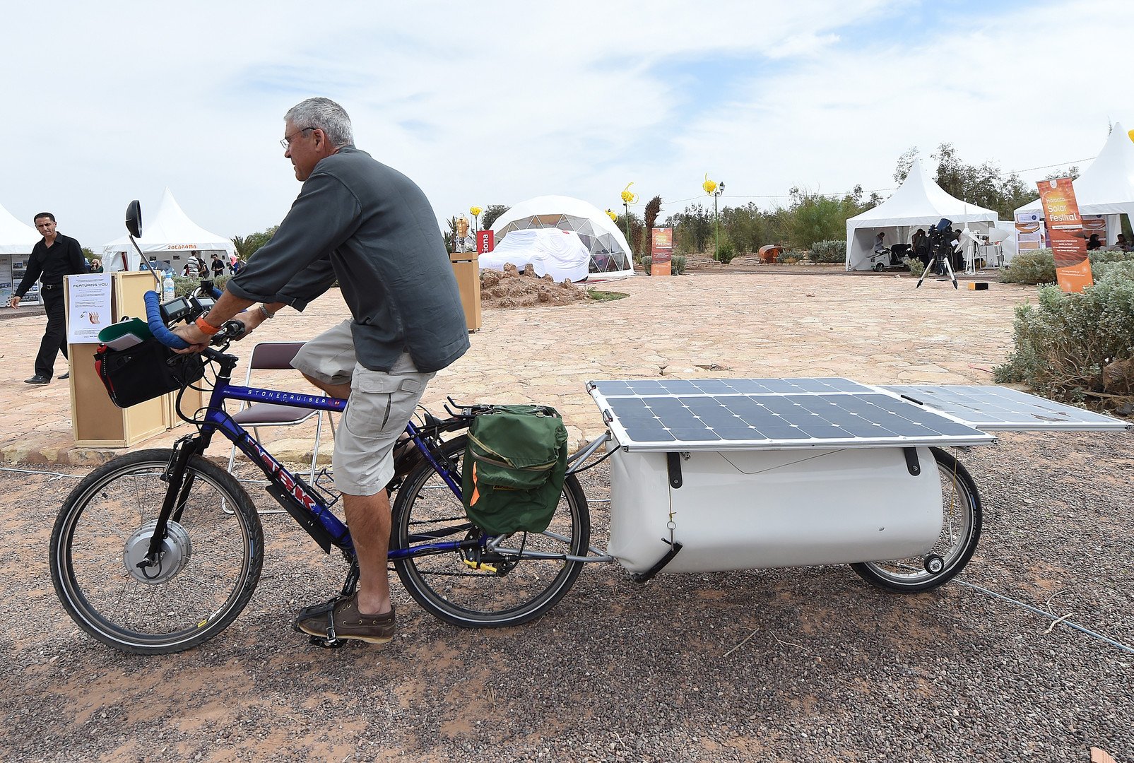رجل يركب دراجة مثبتة عليها الألواح الشمسية خلال مهرجان الطاقة الشمسية بالمغرب
