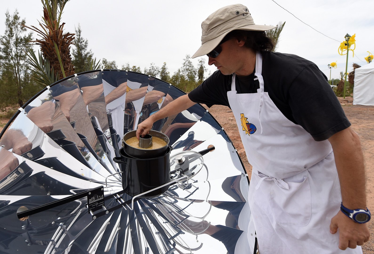  رجل يستخدم الطاقة الشمسية لطهي الطعام، خلال الدورة الأولى من مهرجان المغرب للطاقة الشمسية 