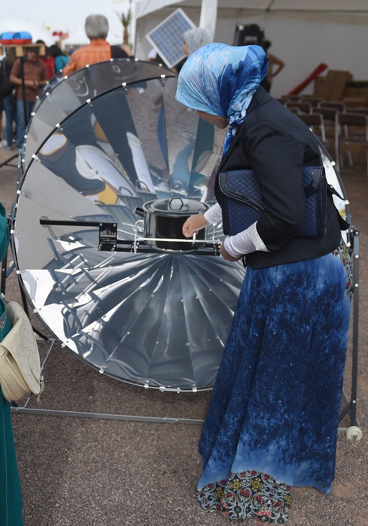 سيدة مغربية تنظر إلى الفرن الشمسي خلال الدورة الأولى من مهرجان المغرب للطاقة الشمسية 