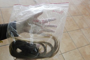  باميلا ماتوس تمسك بحقيبة بلاستيكية تحتوى على بعض من شعرها الذي تبرعت به لإسعاد الأطفال المرضى