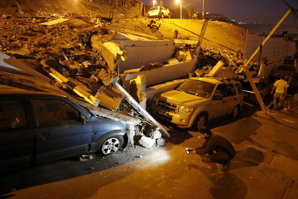 مصور يلتقط صورا لآثار زلزال وتسونامي ضرب ميناء إكويك شمال تشيلي، 2 إبريل/نيسان 2014  